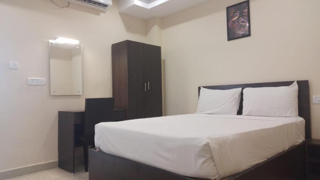 a bedroom with a large bed with white sheets at AB Residency in Chennai
