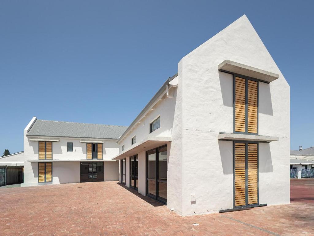 a large white building with windows on a brick yard at Cornercade | Unit 1 in Hermanus