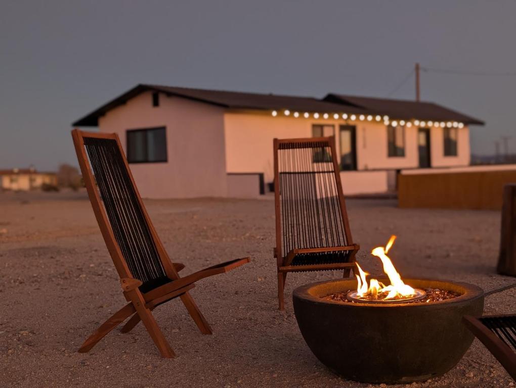 two chairs and a fire pit in front of a building at Golden Moon Hideaway in Twentynine Palms