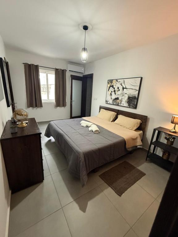 a bedroom with a large bed with two towels on it at 5B Luxury Apartment in Tas-Samra