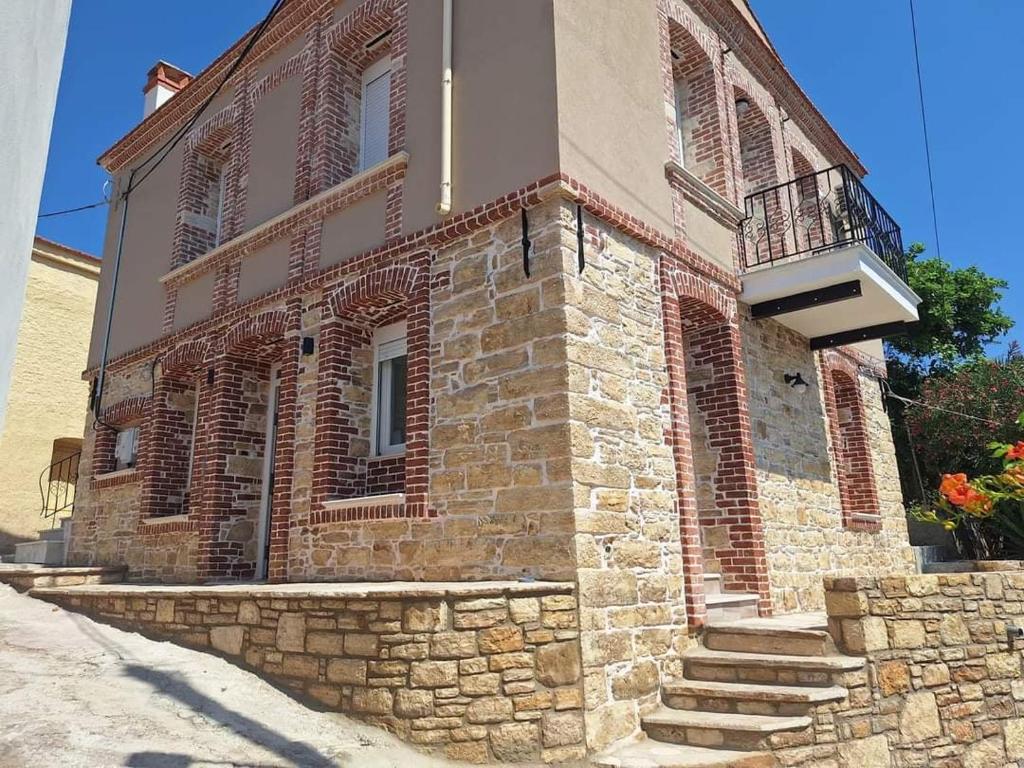 a brick building with a balcony and stairs on it at Villa Kalliope in Nénita