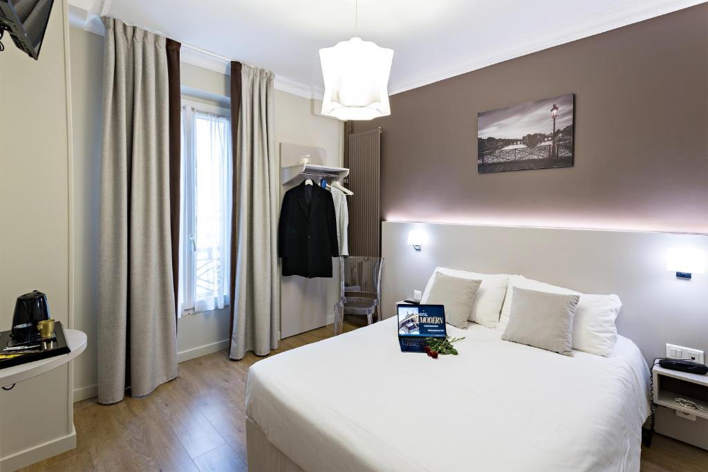 a hotel room with a white bed and a window at Modern Hotel in Paris