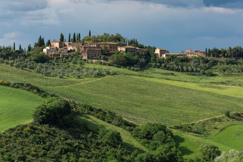 a house on top of a hill with a green field at Agriturismo Borgo d'Asso in San Giovanni dʼAsso