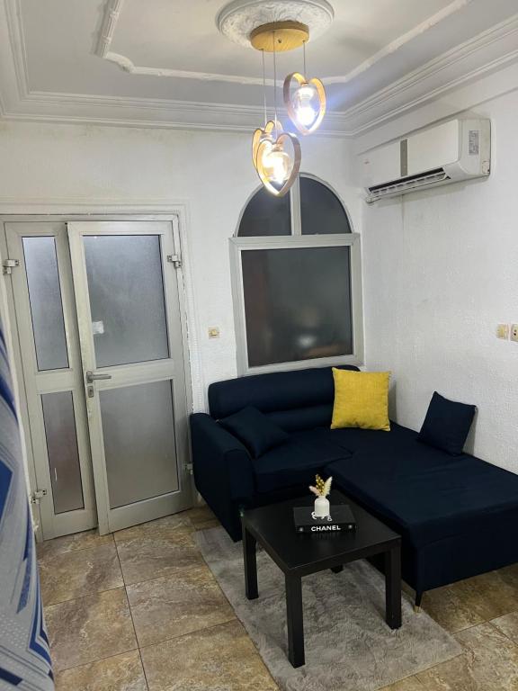un soggiorno con un divano blu e un tavolo di Eleins prestige a Douala