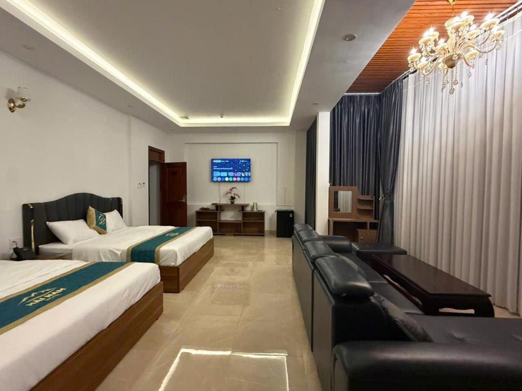 a hotel room with two beds and a television at Hải Nam Hotel Tây Ninh in Tây Ninh