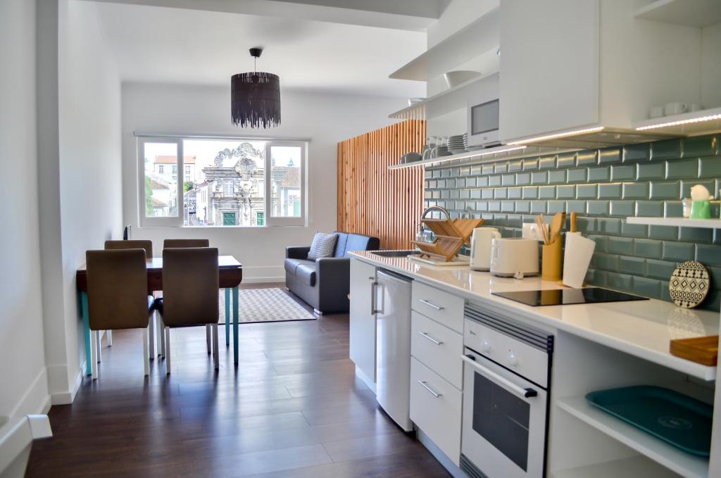 a kitchen and dining room with a table and chairs at A Casa del Rei in Ribeira Grande