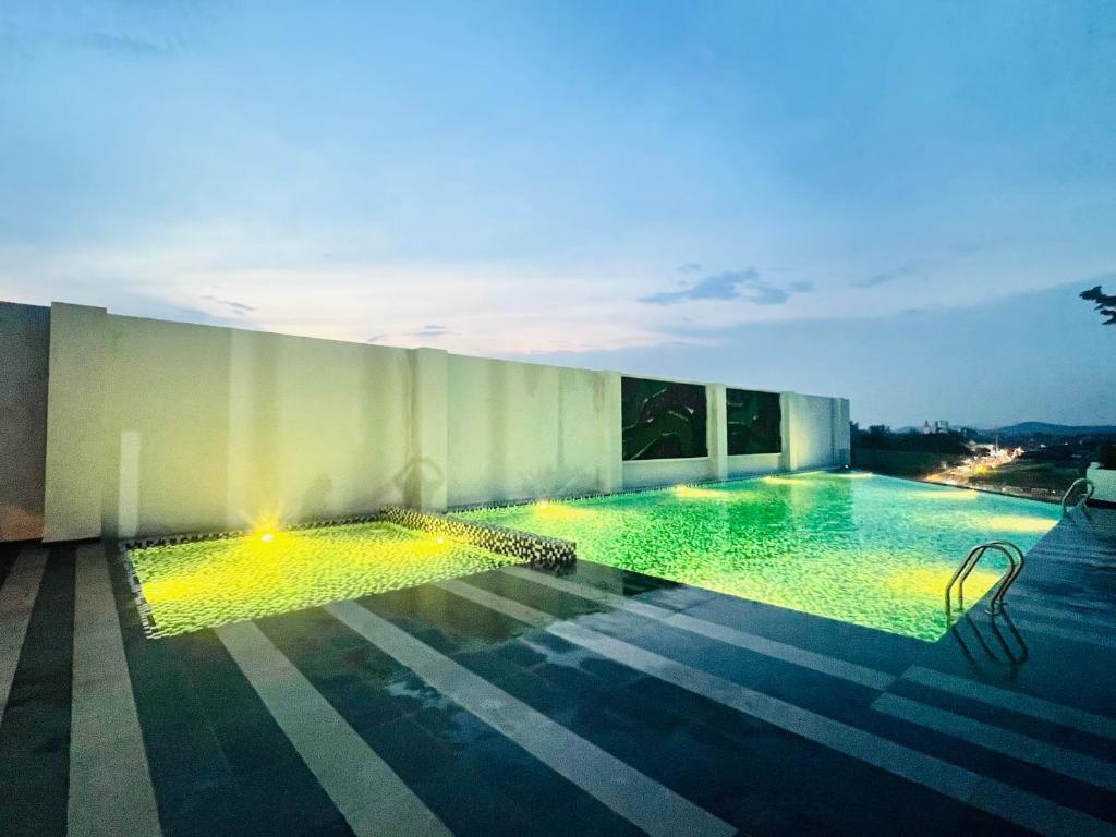 a swimming pool with lights on the side of a building at JC COZYsTAY RAWANG in Rawang