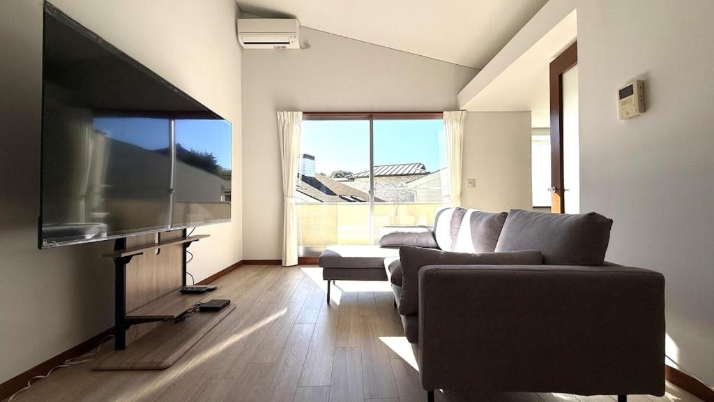 a living room with a couch and a flat screen tv at kamakura retreatB in Kamakura
