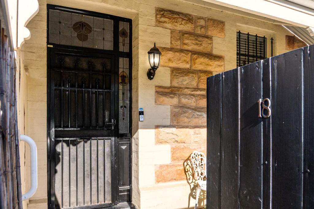 a black door in front of a house at The Arches-Beautiful 3-Bedroom Family Stay Near Adelaide Oval, City Events and Amazing Dining in North Adelaide
