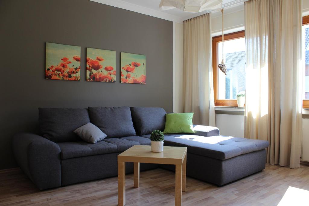 ein Wohnzimmer mit einem blauen Sofa und einem Tisch in der Unterkunft Ferienwohnung Hüsken in Voerde