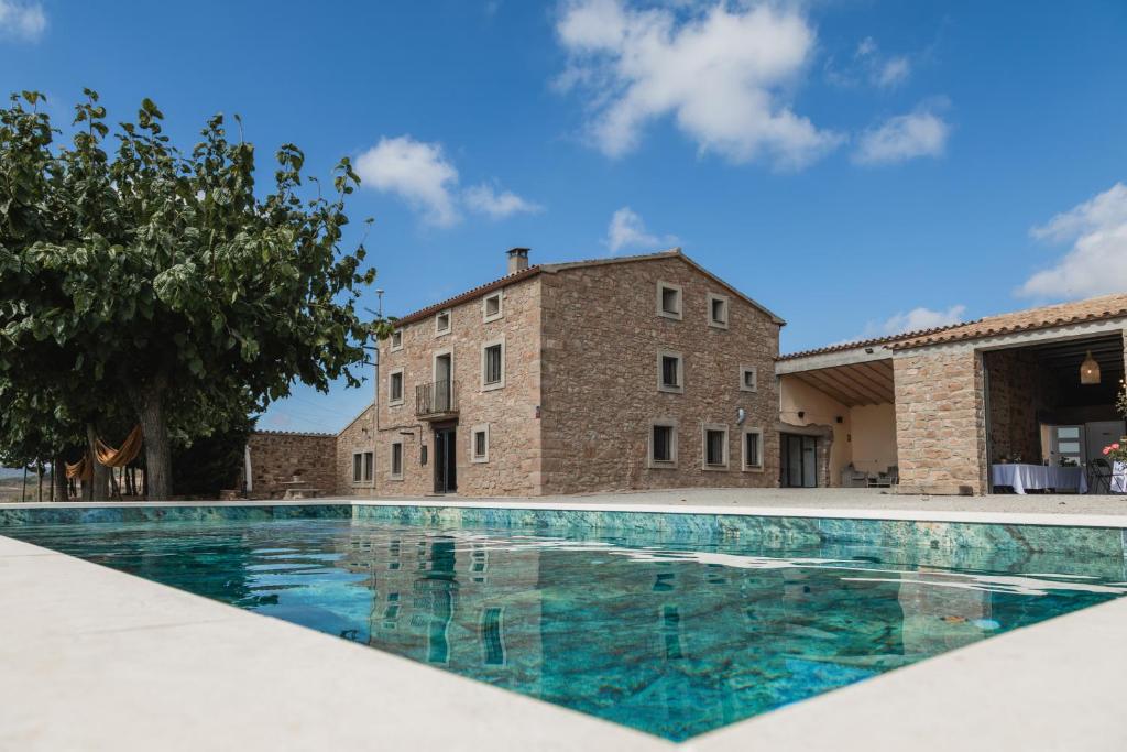 a swimming pool in front of a building at Mas Françó in Argençola
