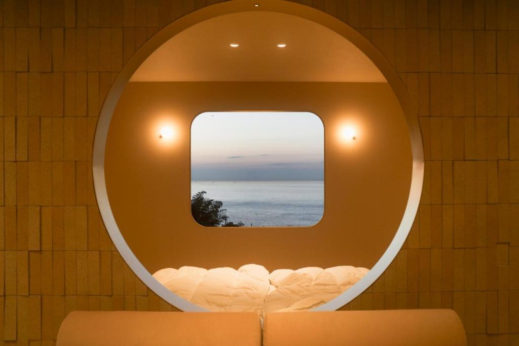 a circular mirror on a wall with a view of the ocean at Over the MOON in Awaji