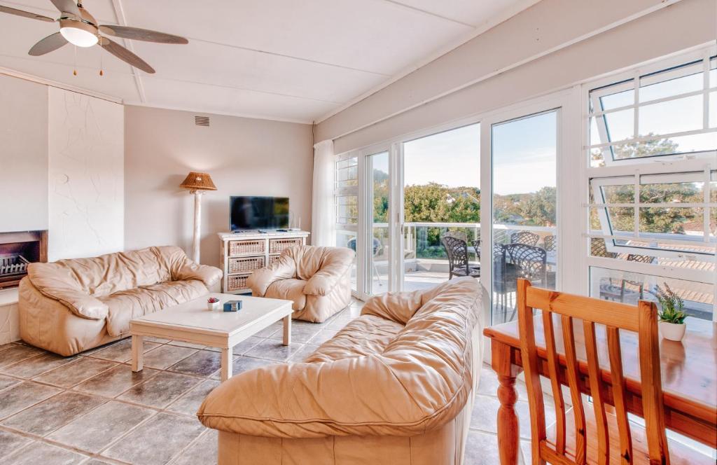 a living room with a couch and a table at Treetops, Amblewood Guesthouse in Kenton on Sea