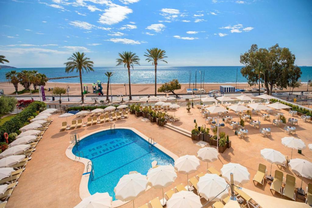 Una vista de la piscina y la playa en un resort. en Hotel Servigroup Trinimar, en Benicàssim