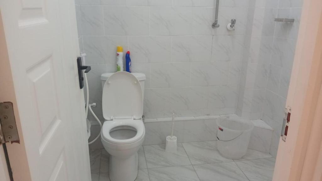 a white bathroom with a toilet and a shower at Lins Haven in Kilifi