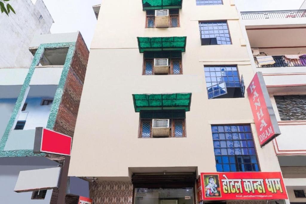a tall white building with green windows at RROOMS Elite Hotel Kanha Cassic in Kānpur