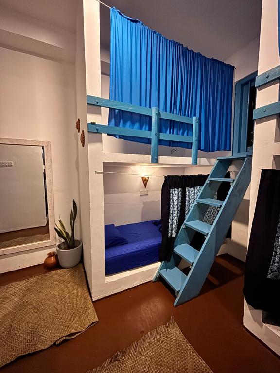 a bedroom with bunk beds with a blue bunk bed at Hostel by Sri villa polwatta in Weligama