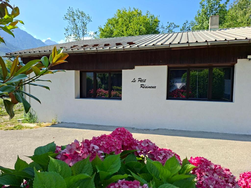 a house with flowers in front of it at Le petit résineux in La Chambre