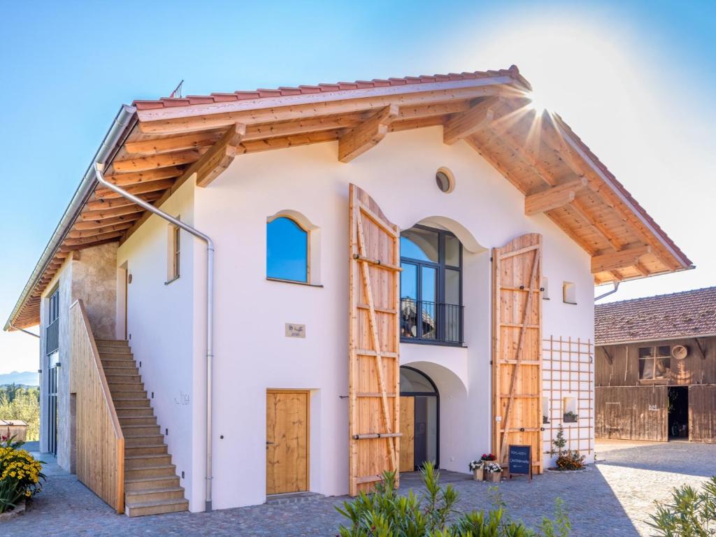 a white house with a wooden roof at Sailerhof Gramminger in Taching am See