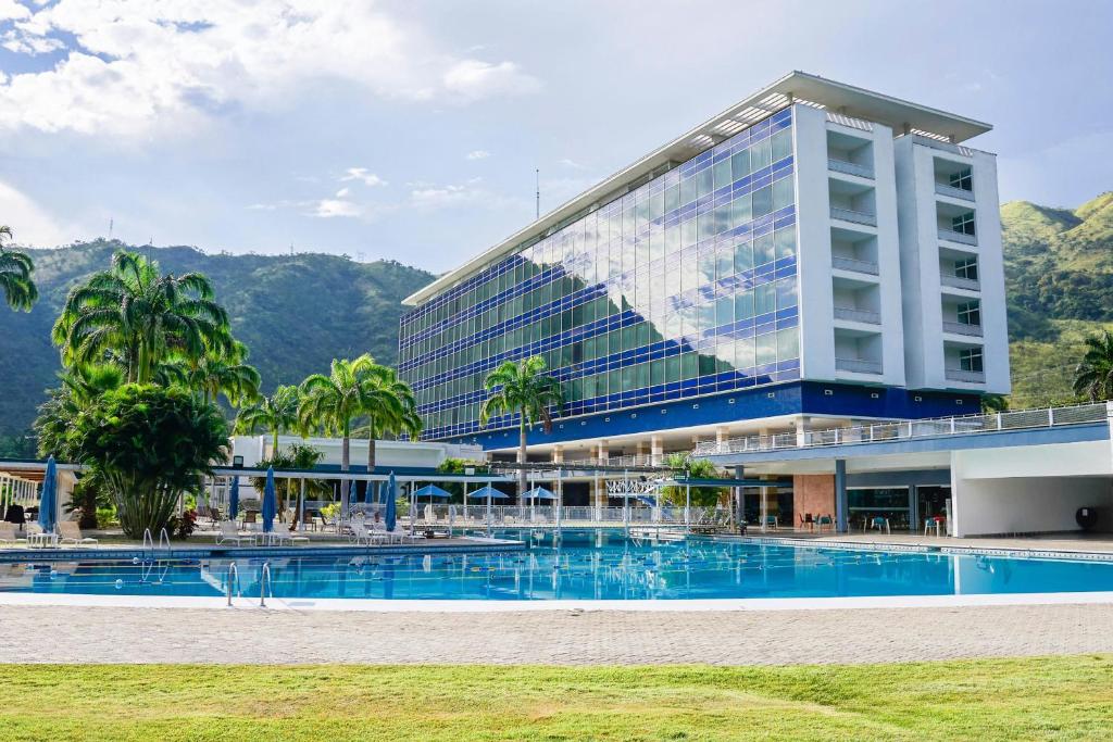 a building with a swimming pool in front of a building at Marriott Maracay Golf Resort in Maracay