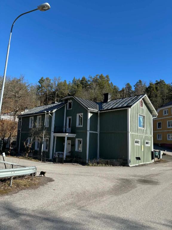 a large green building with a dog in front of it at Kråksjöviken in Västervik