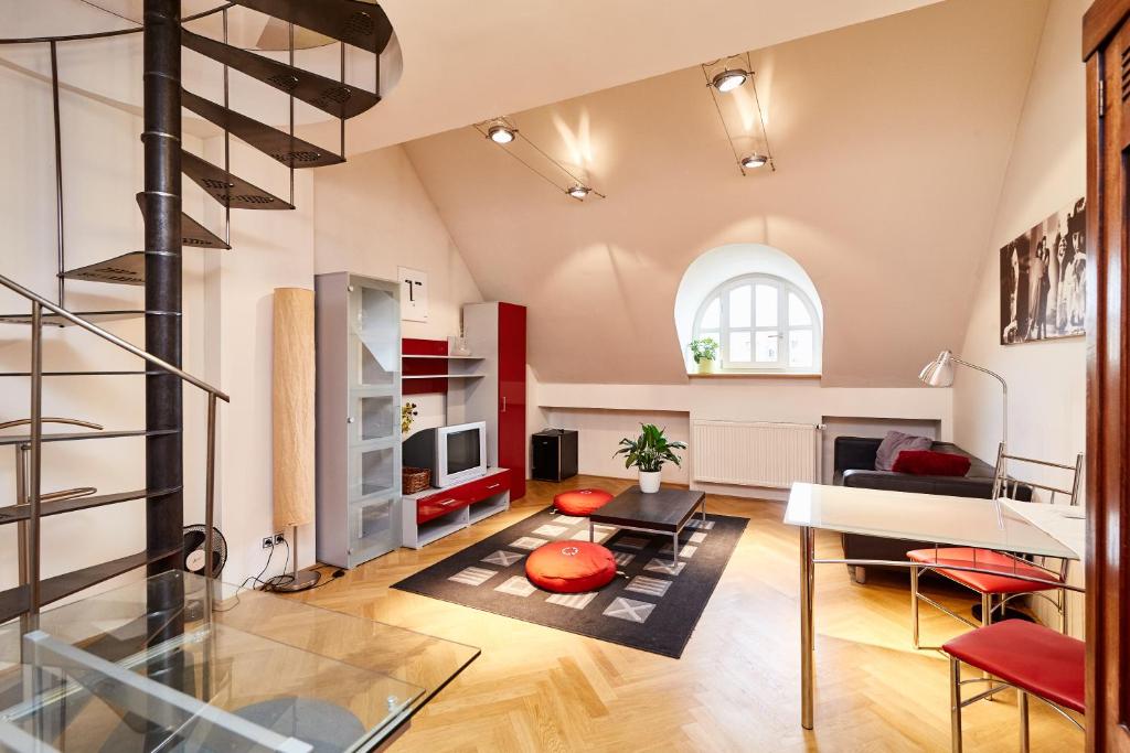 a living room with a staircase and a room with a table at Prague Letna Apartments in Prague