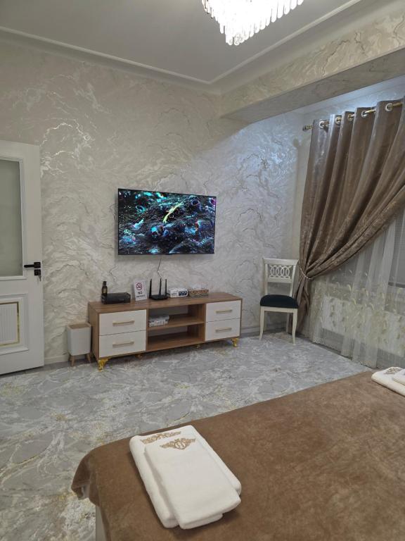 a bedroom with a tv on the wall and a desk at Guest house 2 in Fergana
