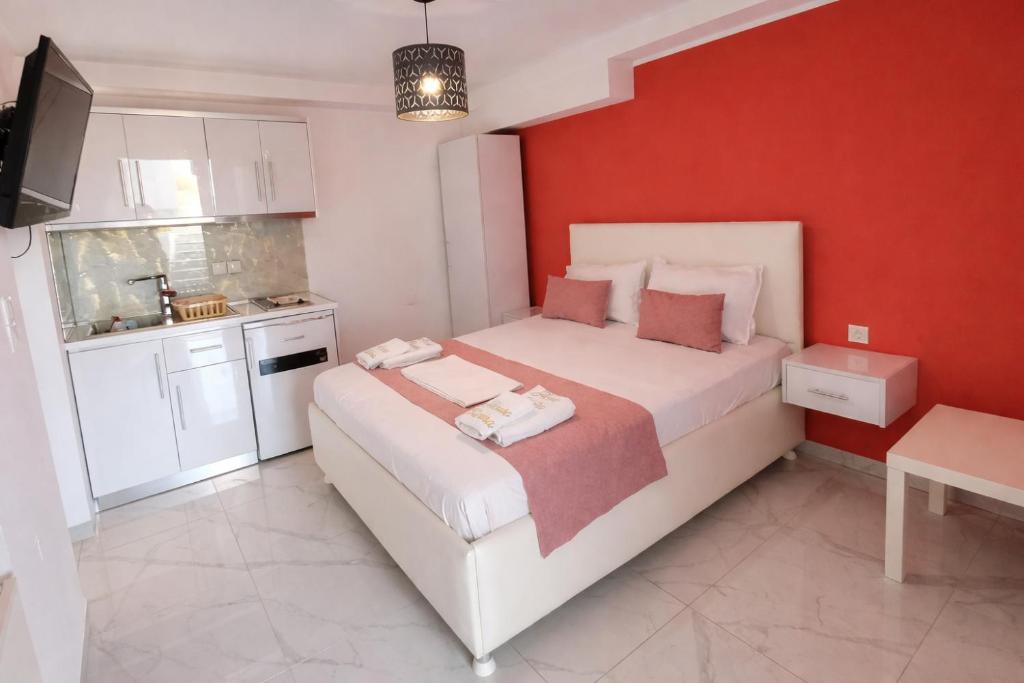 a bedroom with a large bed and a red wall at House Blerina - Sarti Chalkidiki in Sarti