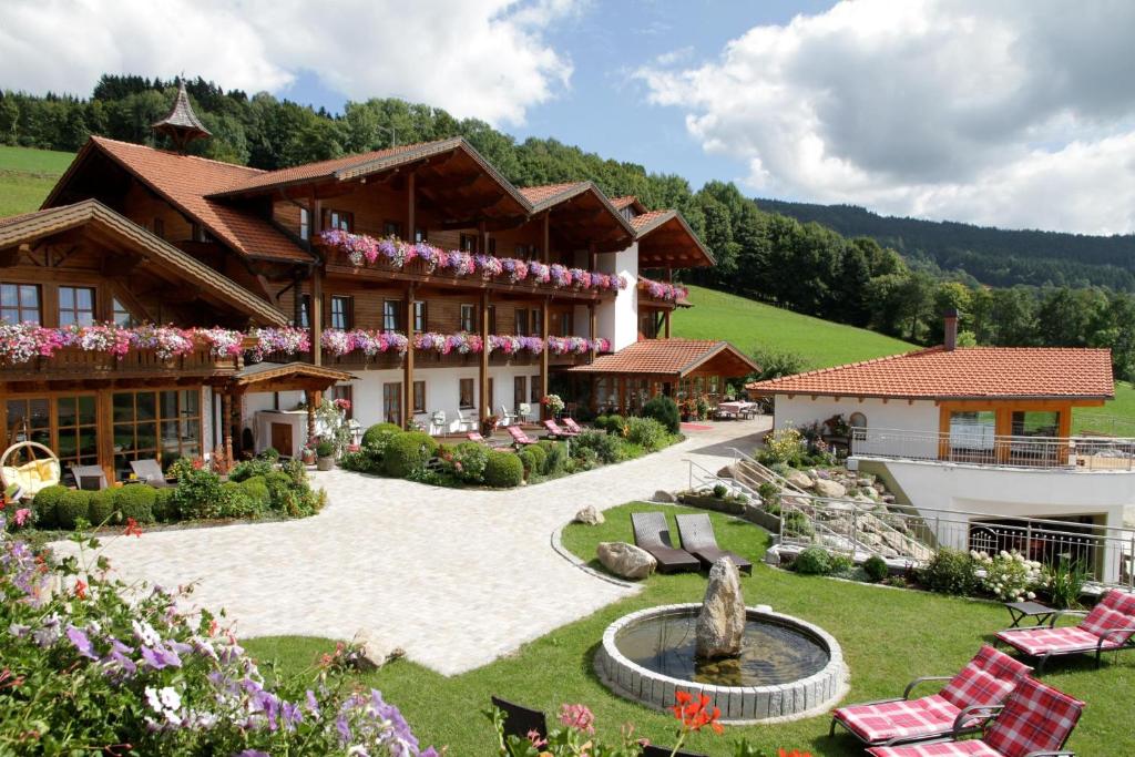 a large building with a fountain in the yard at Musik - und Wellnesshotel Mariandl Singender Wirt in Haibach