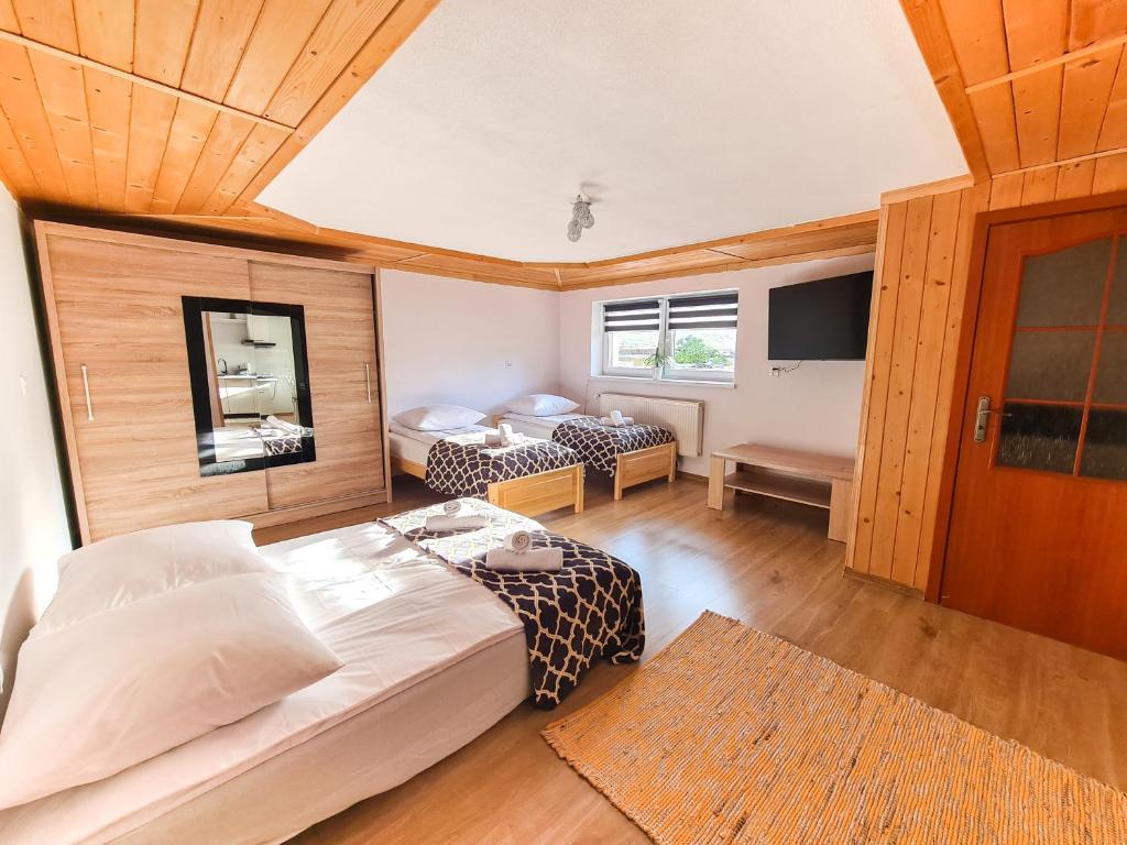 a bedroom with two beds and a tv in it at Apartament Za Potokiem in Groń