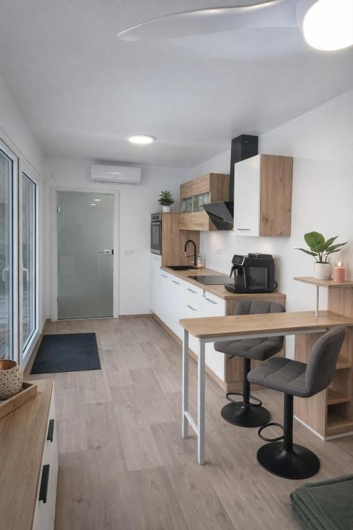 eine Küche mit Holzschränken, einem Tisch und Stühlen in der Unterkunft Auszeitbox in Schärding