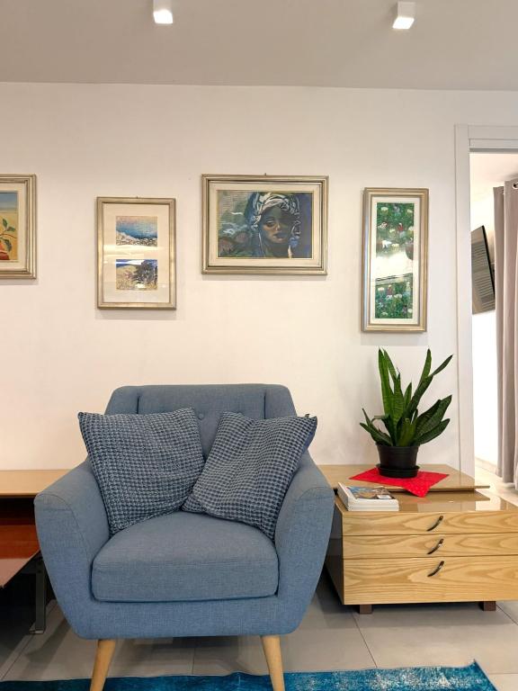 a living room with a blue chair and a table at Villa Delia in Cernobbio