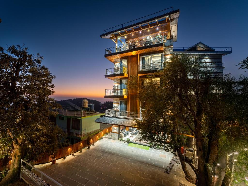 an apartment building with a balcony at night at Moustache Select Mcleodganj in Dharamshala