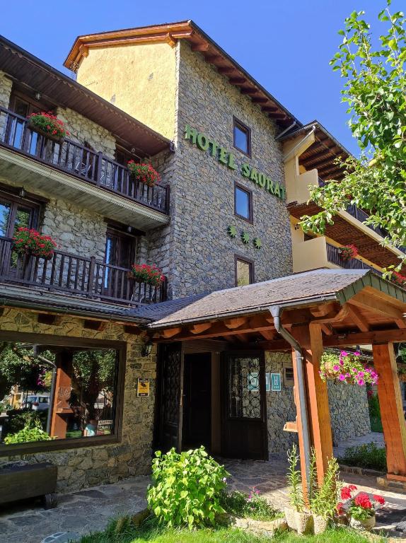 a building with a sign on the side of it at Hotel Saurat in Espot