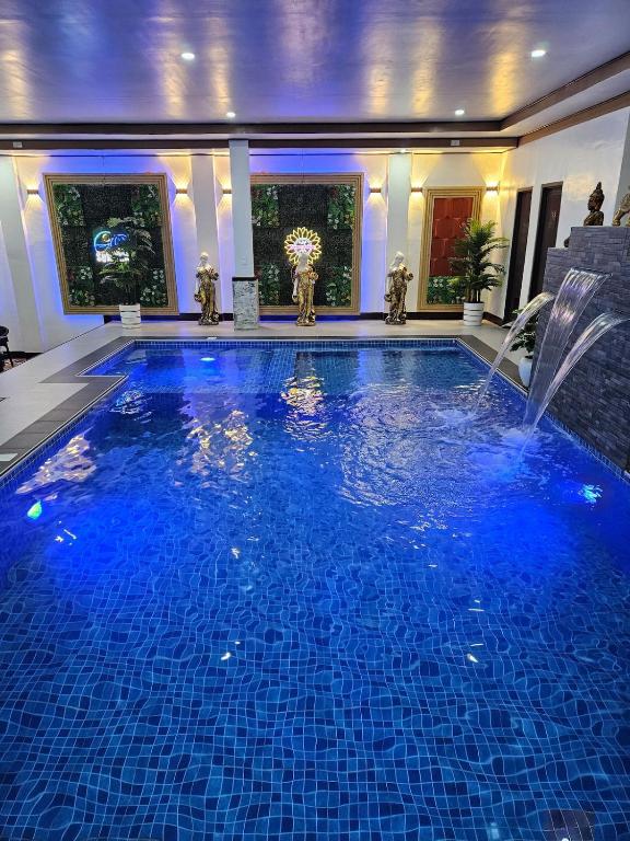 a large swimming pool with a fountain in a house at Private Resort in Batangas in Lian