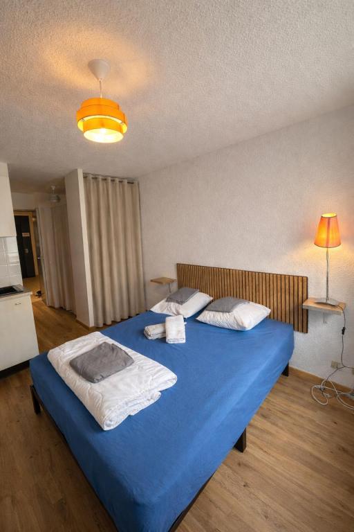 a bedroom with a blue bed with a blue blanket at Logis, appartement, 220 élégant et central in Paray-le-Monial