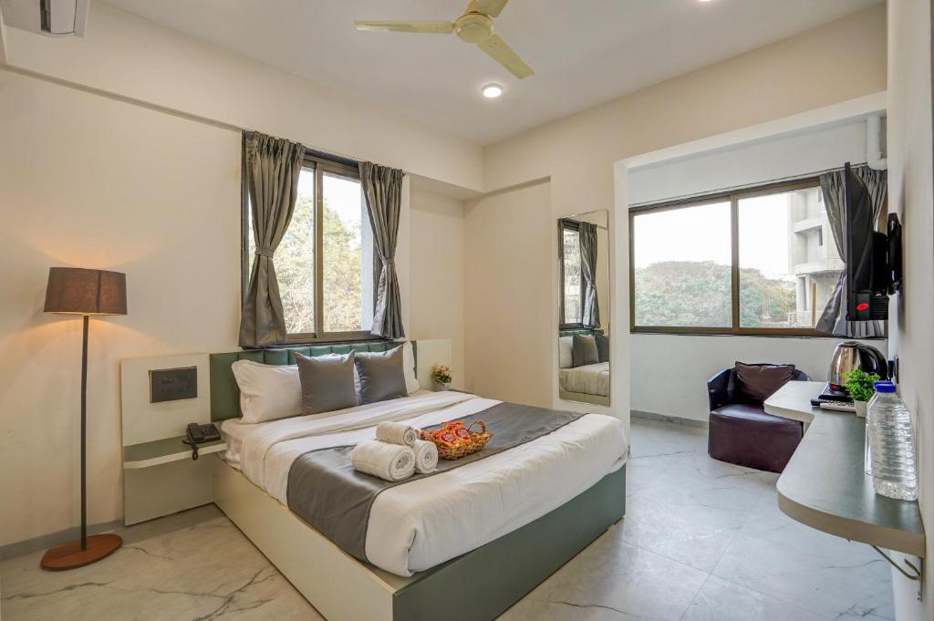 a bedroom with a bed and a desk and windows at Hotel Zenora in Méribel Village