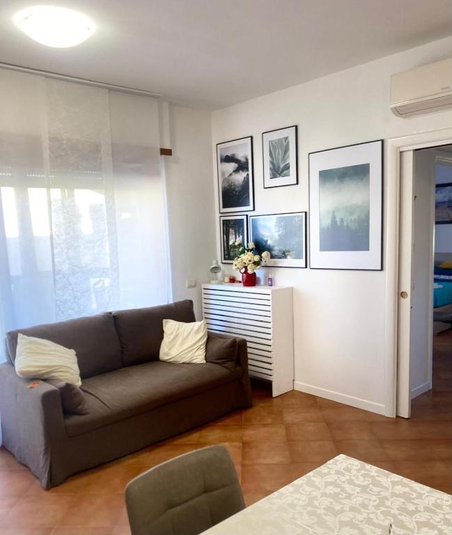 a living room with a couch and pictures on the wall at Granaretto 27 in Palidoro