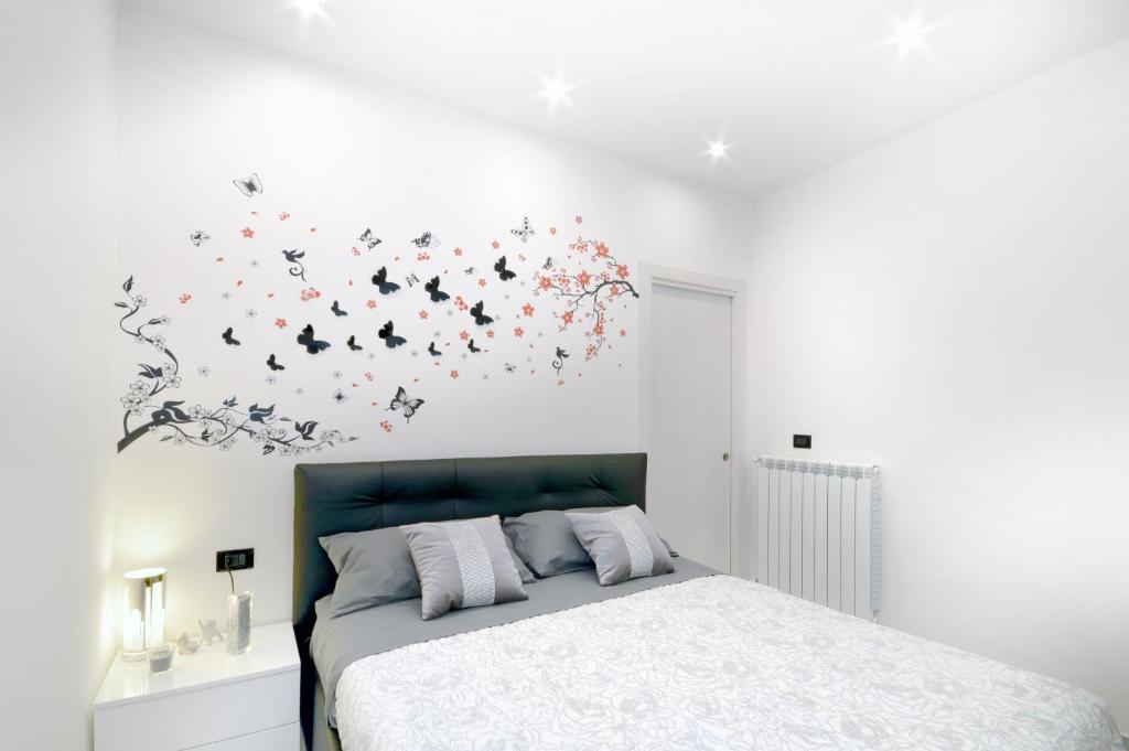 ein Schlafzimmer mit einem Bett mit einem Blumenbild an der Wand in der Unterkunft Home Sweet Home in Neapel