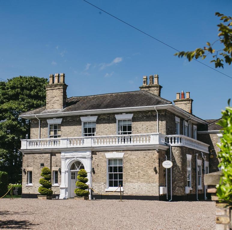 a large brick house with a balcony on it at Dunedin Country House in Patrington