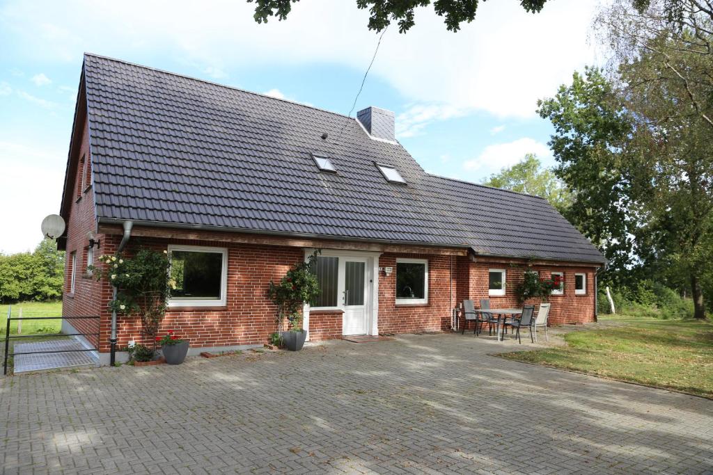 a red brick house with a roof at Ferienhaus Ostsee in Rabenkirchen-Faulück