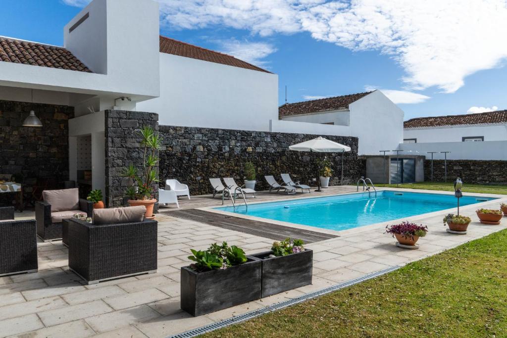 a villa with a swimming pool in a yard at Casa da Arvore Chale by Green Vacations in Calhetas