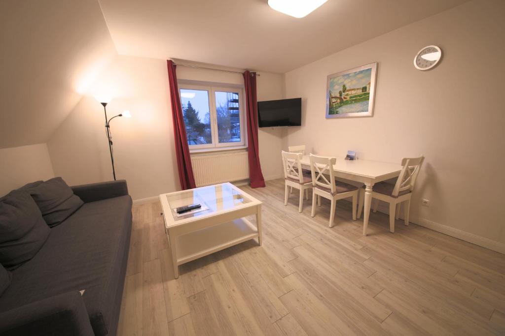 a living room with a couch and a table with chairs at Schleiblick App 5 in Rabenkirchen-Faulück