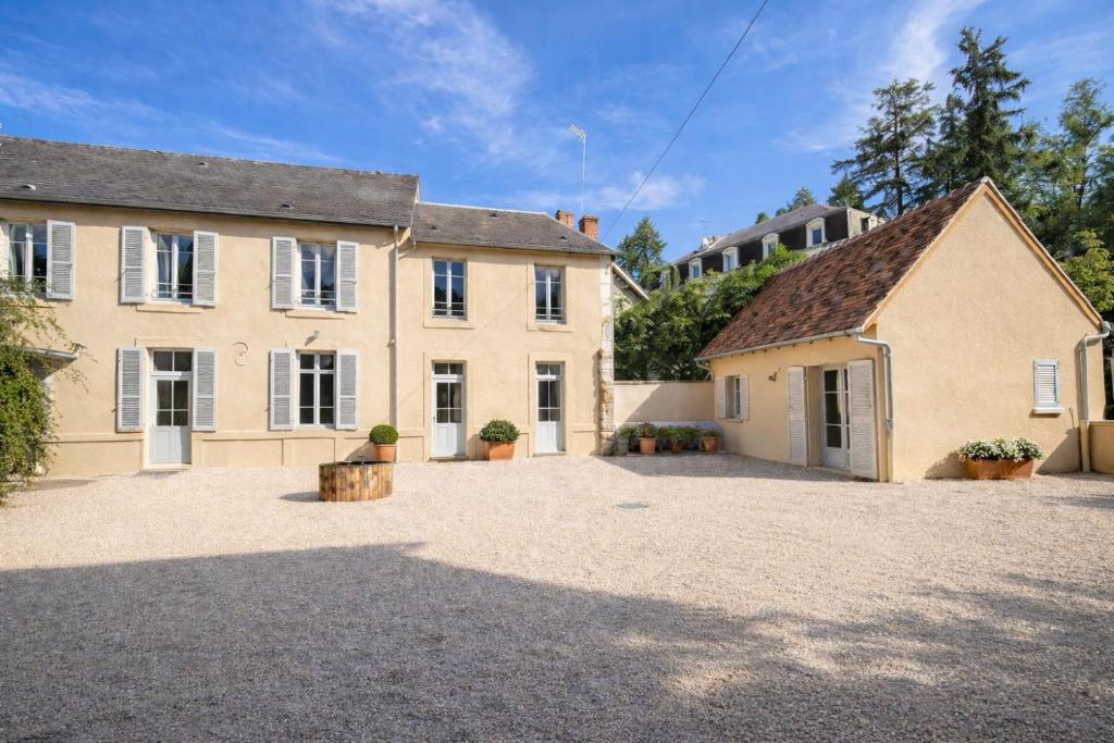an exterior view of a house with a large driveway at Hôtel des Thermes in Bourbon-Lancy