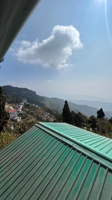 a green roof with a view of a mountain at NV Anjali Homestay in Sukhia Pokhari