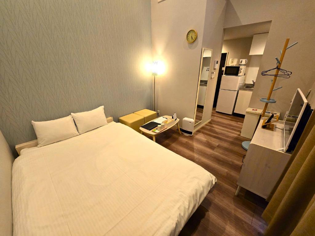 a bedroom with a large white bed in a room at Comfort CUBE PHOENIX Yakuin in Susakiuramachi
