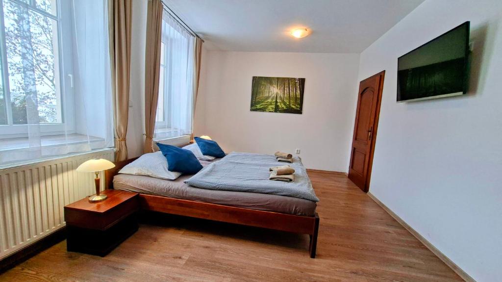 a small bedroom with a bed with blue pillows at Penzion a restaurace Polnička in Polnička