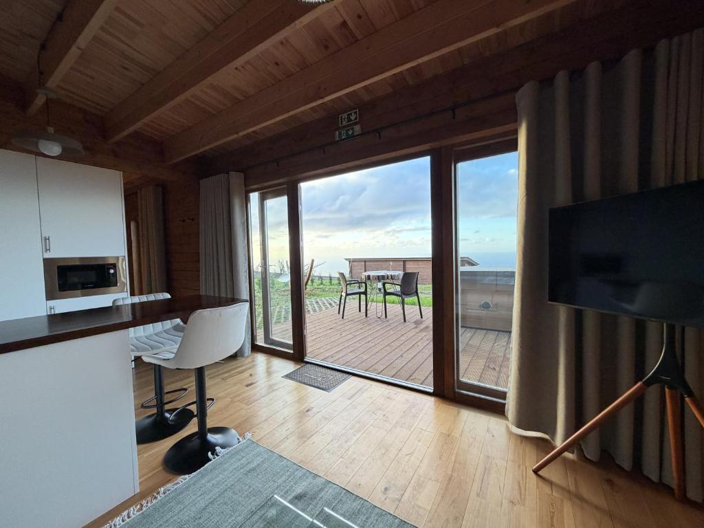 a living room with a large sliding glass door with a balcony at Sunset Eco Shelter 4 in Ponta do Pargo