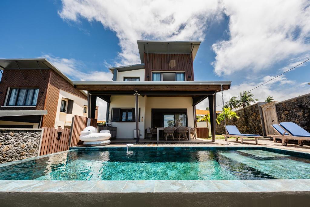 a villa with a swimming pool in front of a house at Villa de Luxe avec Piscine privée chauffée-3 Chambres-Sud Sauvage in Petite Île