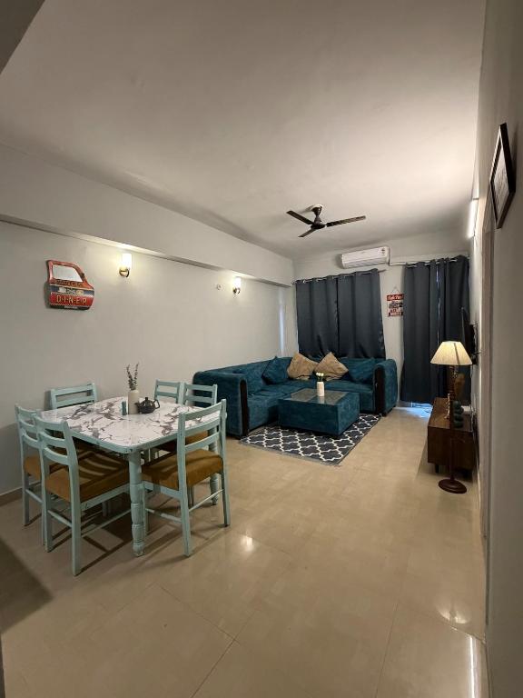 a living room with a table and a couch at Elegant 1BHK at Shiva Stays, behind lulu mall in Lucknow